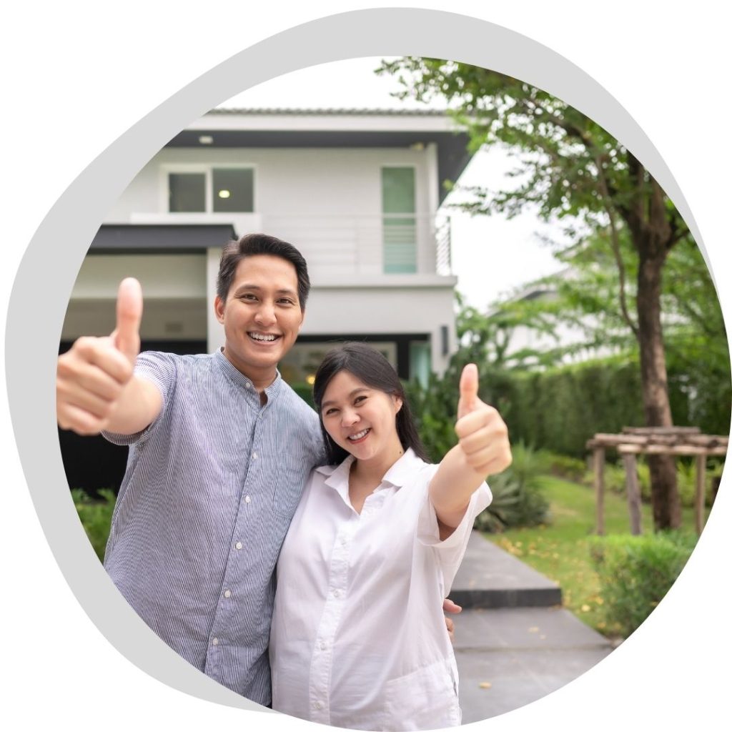 people giving thumbs up standing in front of house